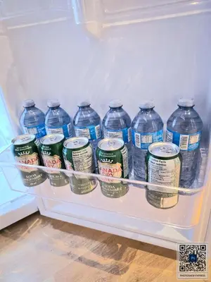 a refrigerator filled with lots of bottles of water at Welcome to your Serene Gateway in London