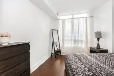 a white bedroom with a bed and a window at Luxurious 2BR 2BATH Condo Steps from Square One in Mississauga