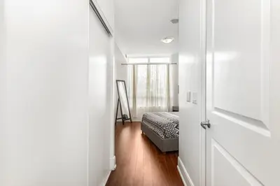 a hallway with a bed in a room with a door at Luxurious 2BR 2BATH Condo Steps from Square One in Mississauga