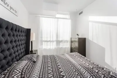 a bedroom with a large bed and a window at Luxurious 2BR 2BATH Condo Steps from Square One in Mississauga