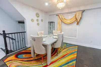a dining room with a table and chairs on a rug at An Ideal Home Away From Home in London