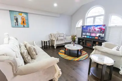 a living room with white furniture and a flat screen tv at An Ideal Home Away From Home in London