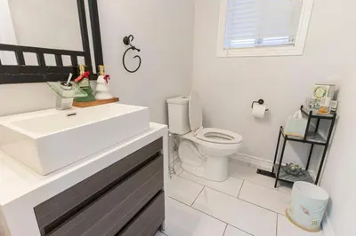 a bathroom with a white sink and a toilet at An Ideal Home Away From Home in London