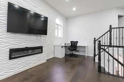 a home office with a flat screen tv on a wall at An Ideal Home Away From Home in London