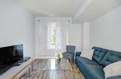 a living room with a blue couch and a television at Luxurious Condo with Balcony in Kitchener in Kitchener