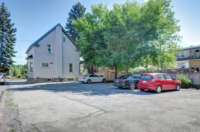 two cars parked in a parking lot in front of a house at Luxurious Condo with Balcony in Kitchener in Kitchener
