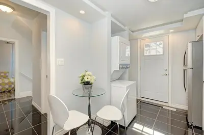 a small kitchen with a glass table and white chairs at Luxurious Condo with Balcony in Kitchener in Kitchener