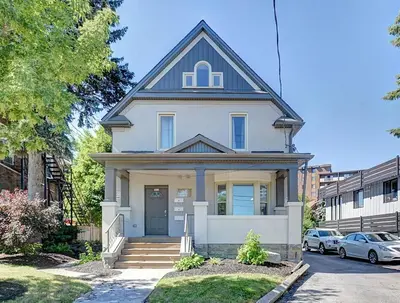 a white house with a blue roof at Luxurious Condo with Balcony in Kitchener in Kitchener