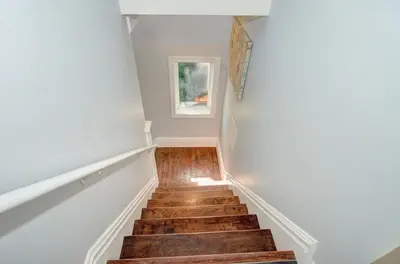 a staircase with wooden floors and a window at Luxurious Condo with Balcony in Kitchener in Kitchener