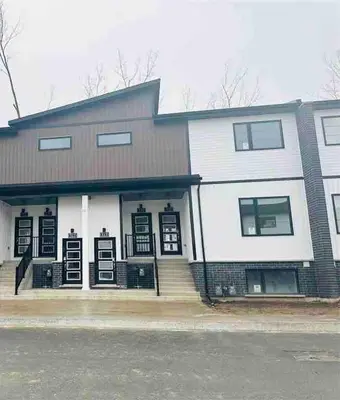a large white house with black doors and windows at Cozy 2Bed Home 6 minutes to the FALLS! in Niagara Falls