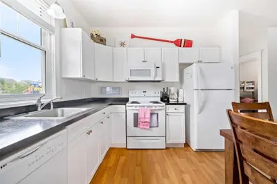 a kitchen with white cabinets and a white refrigerator at 40 Meadow View in Cherry Valley