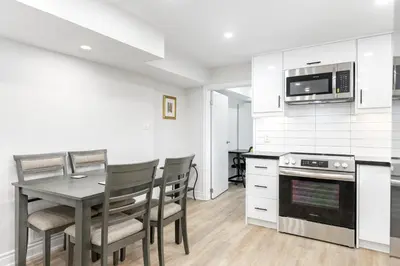 a kitchen with a table and chairs and a microwave at Cozy 2BR Walking distance to Shops in Richmond Hill