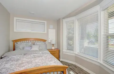 a bedroom with a bed and two windows at Spacious Modern Condo In Kitchener in Kitchener