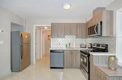 a kitchen with a stainless steel refrigerator and cabinets at Spacious Modern Condo In Kitchener in Kitchener