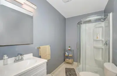 a bathroom with a white sink and a shower at Spacious Modern Condo In Kitchener in Kitchener