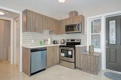 a kitchen with wooden cabinets and a stove top oven at Spacious Modern Condo In Kitchener in Kitchener
