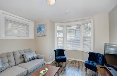 a living room with a couch and two chairs at Spacious Modern Condo In Kitchener in Kitchener