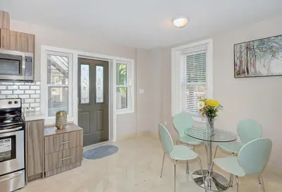a kitchen with a glass table and chairs and a table at Spacious Modern Condo In Kitchener in Kitchener