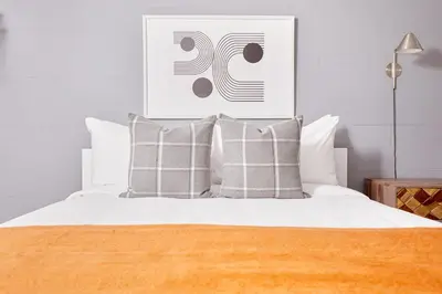 a bedroom with a bed with white sheets and pillows at La TUMU in Toronto