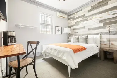 a bedroom with a bed and a table and a desk at La TUMU in Toronto
