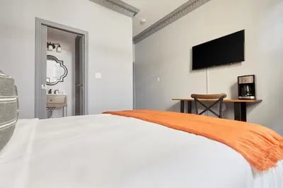 a bedroom with a white bed and a flat screen tv at La TUMU in Toronto