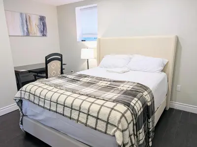 a bedroom with a bed and a desk in it at Kings Palace Basement in Brampton