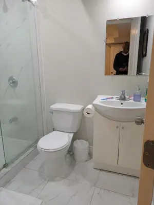a bathroom with a toilet and a sink and a shower at Kings Palace Basement in Brampton