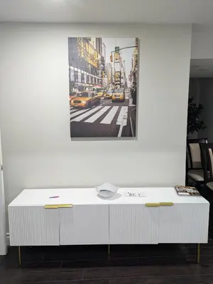 a white table in a room with a picture on the wall at Kings Palace Basement in Brampton