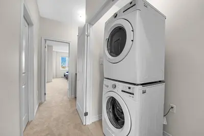 a white laundry room with a washer and dryer at Spacious 6bed Home near Pier Niagara Toronto QEW in Burlington