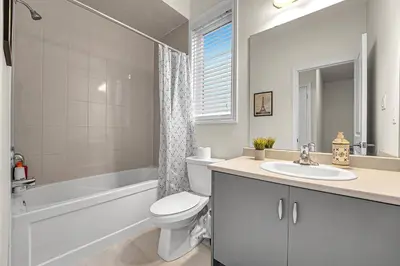 a bathroom with a toilet and a sink and a bath tub at Spacious 6bed Home near Pier Niagara Toronto QEW in Burlington