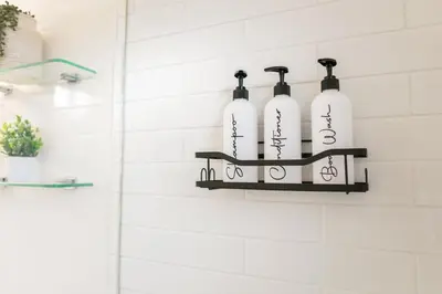 a shelf in a bathroom with four bottles on it at Stylish 3br Home, Close To Restaurantsshops in Mississauga