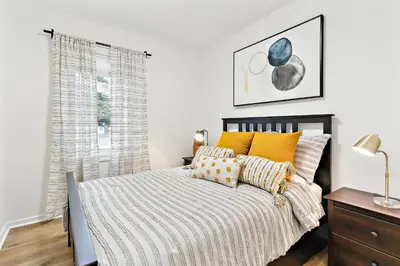 a bedroom with a bed with yellow pillows at Stylish 3br Home, Close To Restaurantsshops in Mississauga