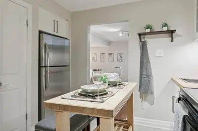 a kitchen with a table with dishes on it at Cozy & Stylish 2br W Hot Tub & Fireplaces in Mississauga