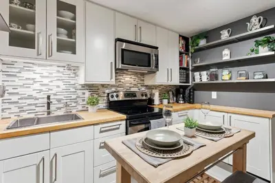 a kitchen with white cabinets and a stove top oven at Cozy & Stylish 2br W Hot Tub & Fireplaces in Mississauga