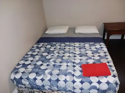 a small bedroom with a bed with a red pillow at Kitchener -WLU BNB-Minutes To University of Waterloo, Conestoga College,Buses,Airport in Waterloo