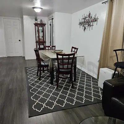 a dining room with a table and chairs on a rug at Queen bedroom in Toronto