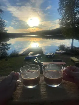 two glasses on a table with a view of a lake at Amazing Lakefront cottage on Paradise Lake in Haliburton