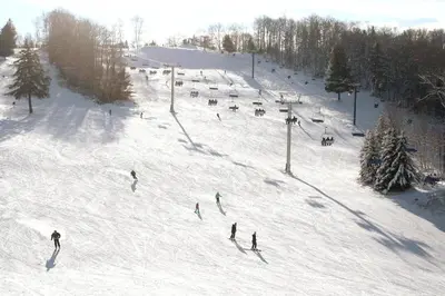 a group of people skiing down a snow covered ski slope at Amazing Lakefront cottage on Paradise Lake in Haliburton