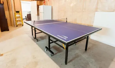a ping pong table in the middle of a room at Amazing Lakefront cottage on Paradise Lake in Haliburton