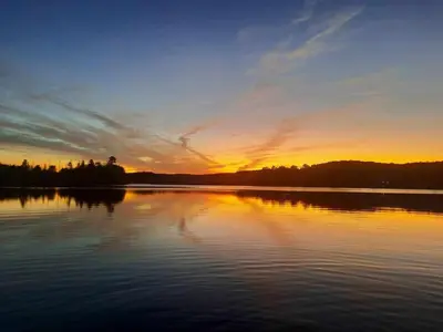 a sunset over a large body of water at Amazing Lakefront cottage on Paradise Lake in Haliburton