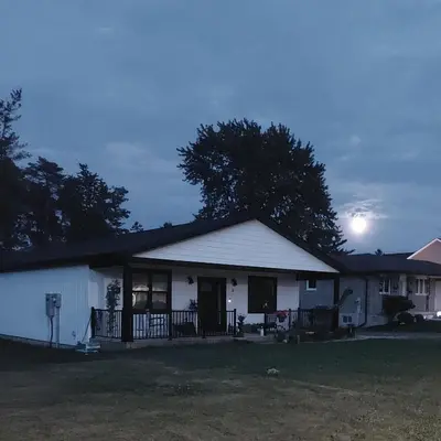 a white house with the sun setting behind it at Soloquester's BnB in Zurich