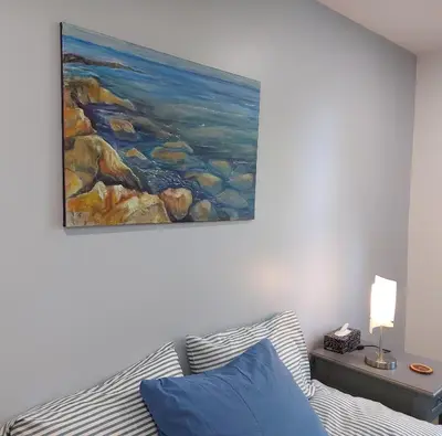 a painting hanging above a bed in a bedroom at Soloquester's BnB in Zurich