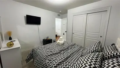a bedroom with a bed with black and white sheets at Dream Homes in Thorold
