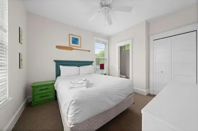 a bedroom with a white bed and a green dresser at The Duskywing - 44 Meadow View in Cherry Valley