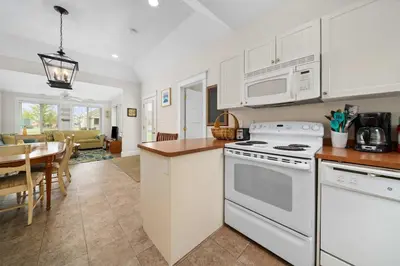 a kitchen with white appliances and a dining room at The Duskywing - 44 Meadow View in Cherry Valley
