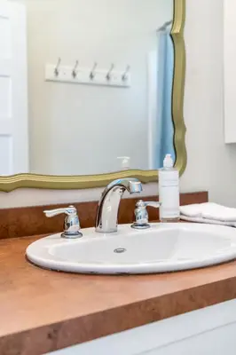 a bathroom counter with a sink and a mirror at The Duskywing - 44 Meadow View in Cherry Valley