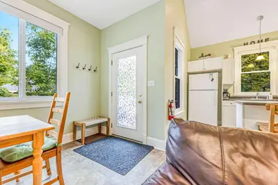 a living room with a table and a kitchen at 5 Farm View in Cherry Valley