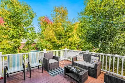 a balcony with chairs and a table and trees at 5 Farm View in Cherry Valley