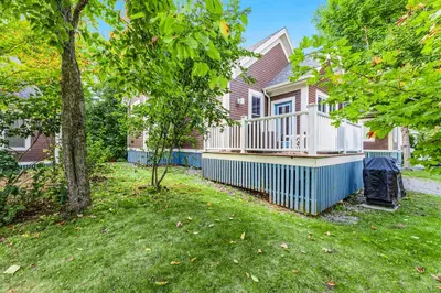a house with a deck and a yard at 5 Farm View in Cherry Valley