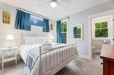 a bedroom with a white bed with blue curtains at 5 Farm View in Cherry Valley